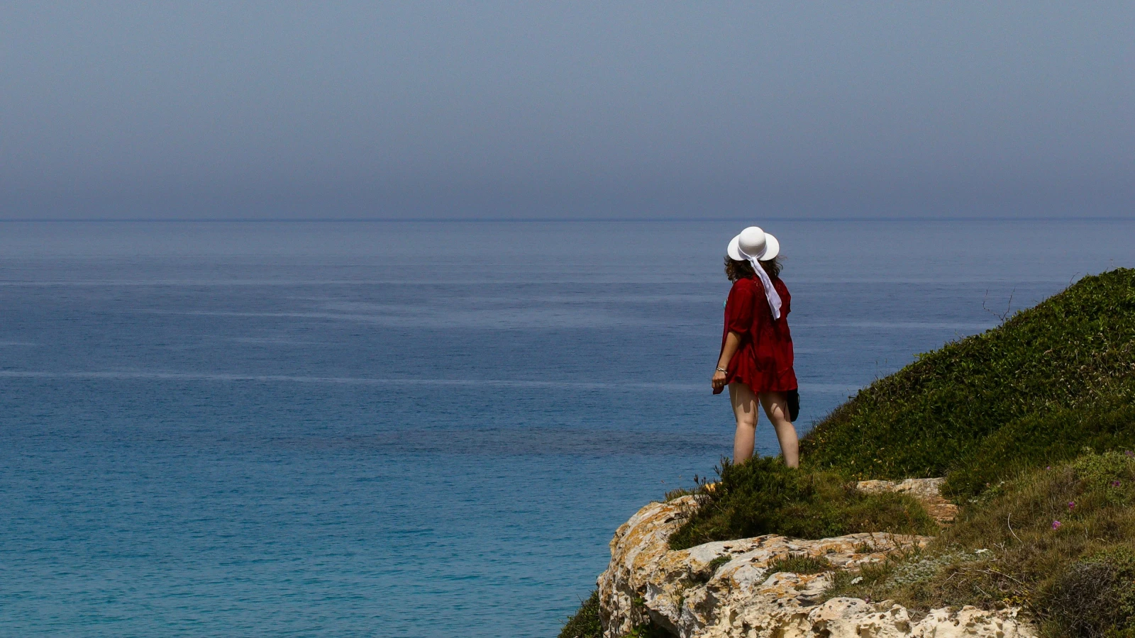 Woman in red dress at Cavo Greco viewpoint Ayia Napa accessible by rental car